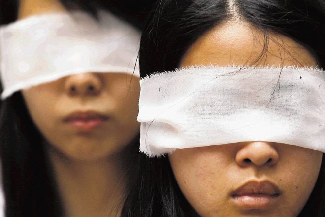 Tako so protestniki v Hongkongu z belimi trakovi, ki simbolizirajo žalovanje, prekrili svoje oči. Protestirali so zaradi...