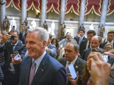 Speaker of the House Kevin McCarthy, R-Calif., is surrounded by police and press on the way to the chamber, at the Capitol in Washington, Tuesday, Oct. 3, 2023. McCarthy's ability to remain in leadership is now seriously at risk after the House voted to move ahead with an effort by hard-right Republican critics to oust him. Tuesday's narrow vote was forced by McCarthy's chief rival, Rep. Matt Gaetz of Florida. (AP Photo/Mark Schiefelbein)