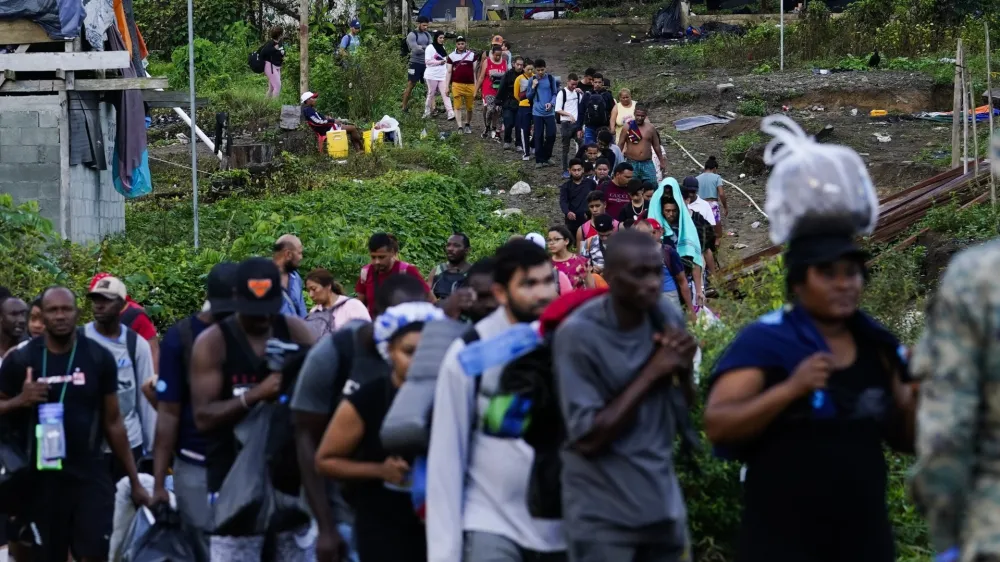 Migrants heading north line up to take a boat, in Bajo Chiquito, Darien province, Panama, Thursday, Oct. 5, 2023, after walking across the Darien Gap from Colombia. (AP Photo/Arnulfo Franco)