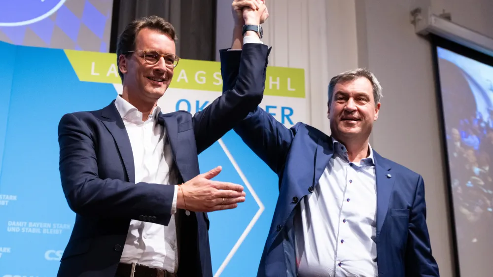 06 October 2023, Bavaria, Nuremberg: Minister President of Bavaria Markus Soeder (R) and Minister President of North Rhine-Westphalia Hendrik Wuest hold their hands during the Christian Social Union in Bavaria (CSU) state election closing rally at the Loewenbraukeller. Photo: Sven Hoppe/dpa