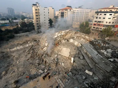 Palestinians inspect the ruins of Watan Tower, which was destroyed in Israeli strikes, in Gaza City October 8, 2023. REUTERS/Mohammed Salem