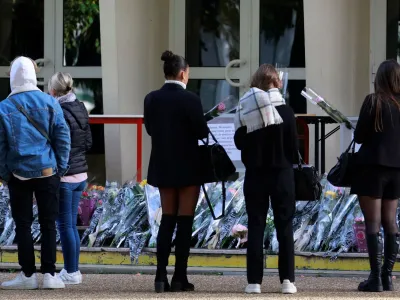 French students and teachers lay flowers in front of the Gambetta-Carnot school to pay tribute to French teacher Dominique Bernard who was killed in a knife attack, in Arras, northern France, October 16, 2023. REUTERS/Pascal Rossignol