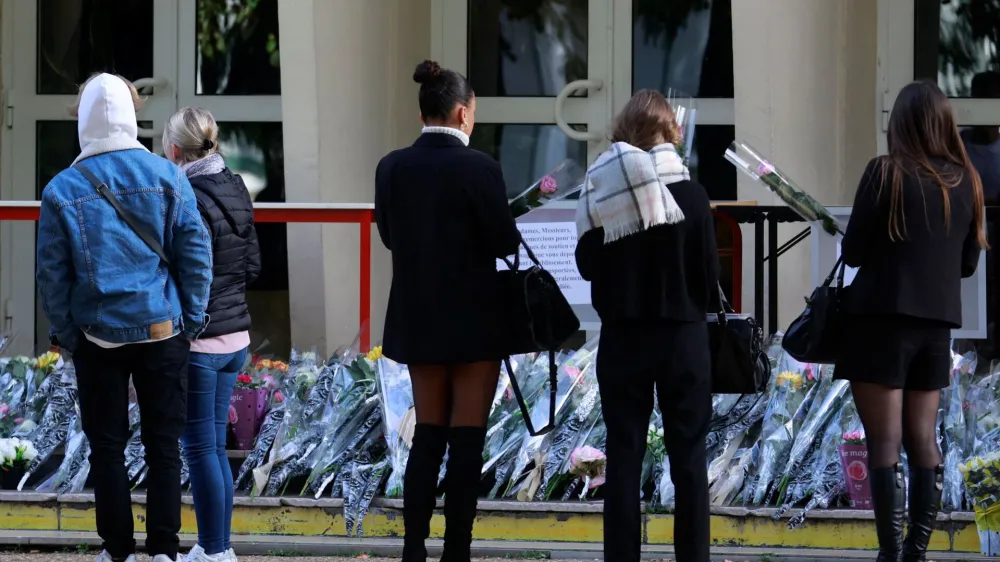 French students and teachers lay flowers in front of the Gambetta-Carnot school to pay tribute to French teacher Dominique Bernard who was killed in a knife attack, in Arras, northern France, October 16, 2023. REUTERS/Pascal Rossignol