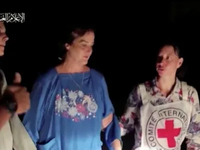 Judith Tai Raanan and her daughter Natalie Shoshana Raanan, U.S. citizens who were taken as hostages by Palestinian Hamas militants, are assisted by a Red Cross official after they were released by the militants, in response to Qatari mediation efforts, in Gaza Strip in this still picture taken from a video obtained by Reuters on October 21, 2023. Al-Qassam Brigade via Telegram/Handout via REUTERS THIS IMAGE HAS BEEN SUPPLIED BY A THIRD PARTY