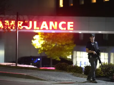 A law enforcement officer carries a rifle outside Central Maine Medical Center during an active shooter situation, in Lewiston, Maine, Wednesday, Oct. 25, 2023. (AP Photo/Steven Senne)