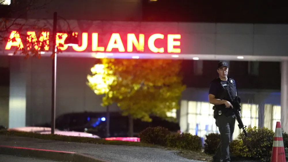 A law enforcement officer carries a rifle outside Central Maine Medical Center during an active shooter situation, in Lewiston, Maine, Wednesday, Oct. 25, 2023. (AP Photo/Steven Senne)