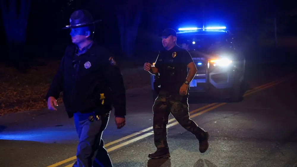 Members of law enforcement work at the scene where the body of Robert Card, the suspect in the mass shootings in Lewiston, was found in Lisbon Falls, Maine, U.S., October 27, 2023. REUTERS/Shannon Stapleton