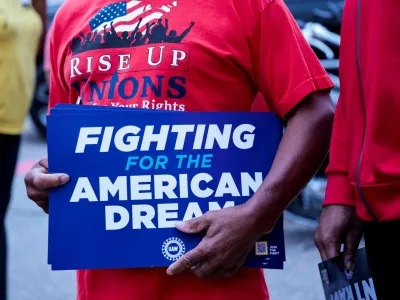 FILE PHOTO: A United Auto Workers union member holds a sign outside Stellantis Sterling Heights Assembly Plant, to mark the beginning of contract negotiations in Sterling Heights, Michigan, U.S. July 12, 2023. REUTERS/Rebecca Cook/File Photo