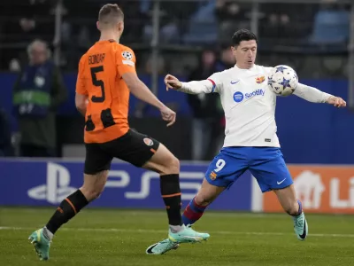 Barcelona's Robert Lewandowski, right, controls the ball as Shakhtar's Valeriy Bondar defends during the Champions League Group H soccer match between Shakhtar Donetsk and Barcelona, at the Volksparkstadion in Hamburg, Germany, Tuesday, Nov. 7, 2023. (AP Photo/Matthias Schrader)