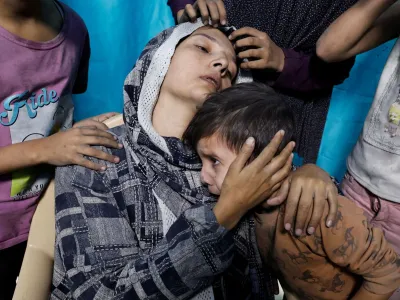 A Palestinian woman and children react after Israeli strikes, at a hospital in Khan Younis in the southern Gaza Strip November 13, 2023. REUTERS/Mohammed Salem