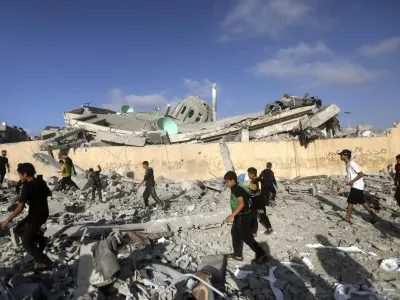 FILE - Palestinians inspect the damage of a destroyed mosque following an Israeli airstrike in Khan Younis refugee camp, southern Gaza Strip on Nov. 8, 2023. Entire generations of Palestinian families in the besieged Gaza Strip have been killed in airstrikes in the ongoing Hamas-Israel war. They include infants to elderly grandparents, killed in attacks the Israeli army says aim to root out the militant group from the densely populated coastal territory. (AP Photo/Mohammed Dahman, File)