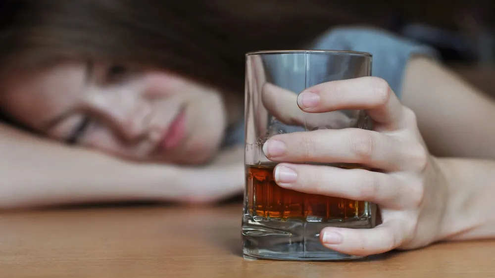 ﻿Drunk female with a glass of whiskey