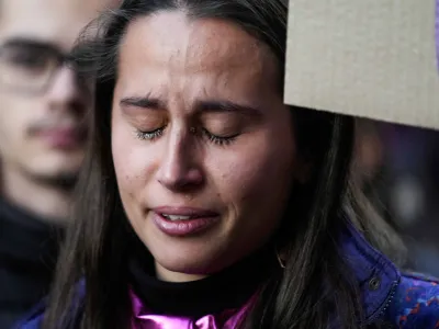 A student cries as she participates in a flash mob 'A minute of noise for Giulia' outside the Statale University, in Milan, Italy, Wednesday, Nov. 22, 2023. Italy has erupted in outrage over the death of a young woman, allegedly at the hands of her possessive ex-boyfriend. It's the latest in a series of cases of gender-based violence that has claimed the lives of more than 50 women so far this year in Italy. (AP Photo/Luca Bruno)