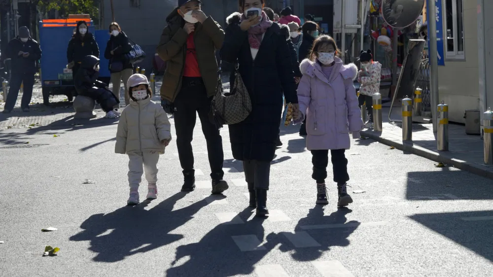 Residents wearing masks pass by a children's hospital in Beijing, Friday, Nov. 24, 2023. Chinese officials say they did not detect any "unusual or novel diseases" in the country, the World Health Organization said Thursday, following an official request by the U.N. health agency for information about a potentially worrying spike in respiratory illnesses and clusters of pneumonia in children. (AP Photo/Ng Han Guan)