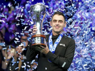 Ronnie O'Sullivan celebrates with the trophy after winning the final against Ding Junhui on day nine of the Snooker UK Championship at the York Barbican, Sunday, Dec. 3, 2023, in York, England. (Mike Egerton/PA via AP)