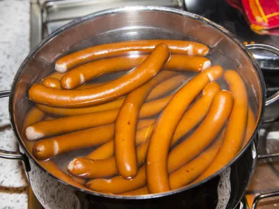 sausages are boiling in a pot of water