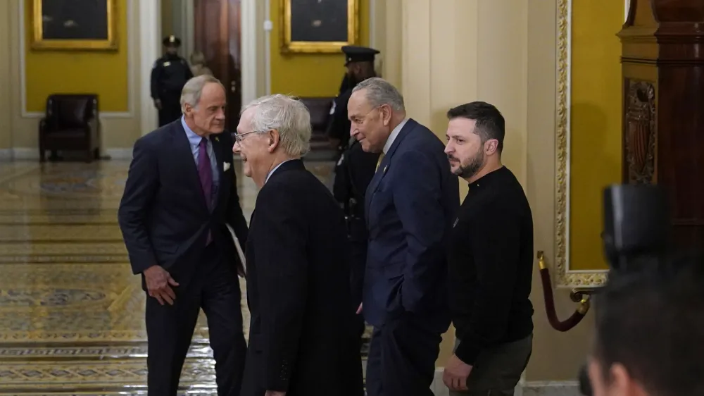 Ukrainian President Volodymyr Zelenskyy, right, walks with Senate Majority Leader Chuck Schumer of N.Y., second from right, and Senate Minority Leader Mitch McConnell of Ky., second from left, following a meeting with senators on Capitol Hill in Washington, Tuesday, Dec. 12, 2023. Sen. Tom Carper, D-Del., is at left. (AP Photo/Susan Walsh)