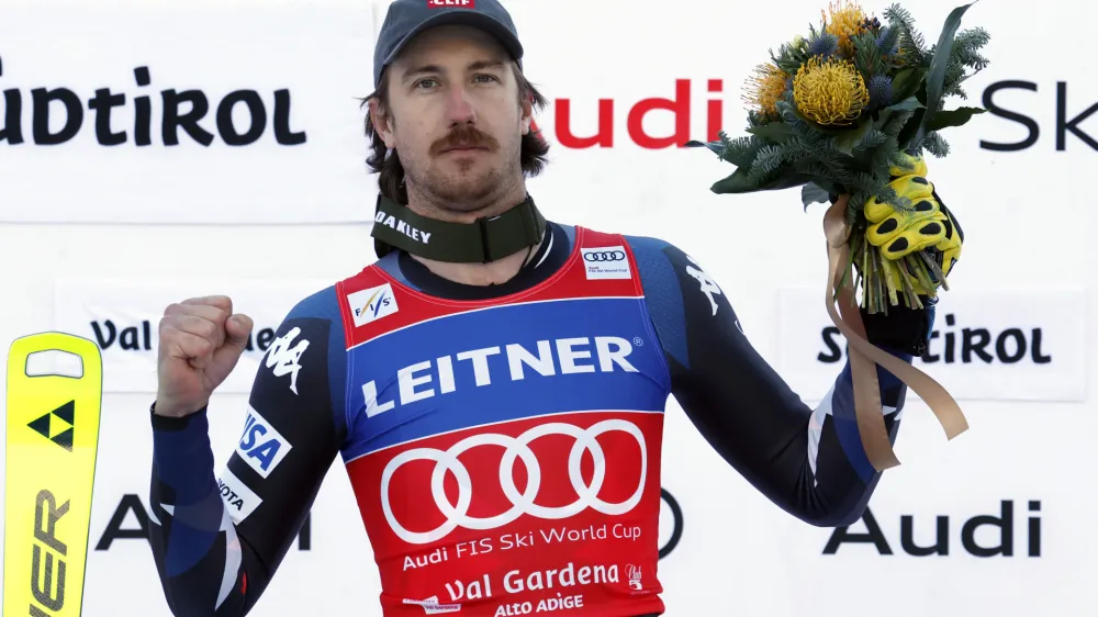 United States' Bryce Bennett celebrates on the podium after winning an alpine ski, men's World Cup downhill race, in Val Gardena, Italy, Thursday, Dec. 14, 2023. (AP Photo/Alessandro Trovati)