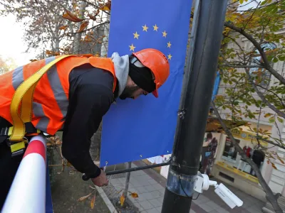 Worker Goga Akhvlediani hangs a banner with a European Union flag on a street in Tbilisi, Georgia December 15, 2023. REUTERS/Irakli Gedenidze