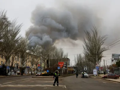 Traffic police officers block a road as smoke rises above buildings following recent shelling in the course of Russia-Ukraine conflict in Donetsk, Russian-controlled Ukraine, December 21, 2023. REUTERS/Alexander Ermochenko