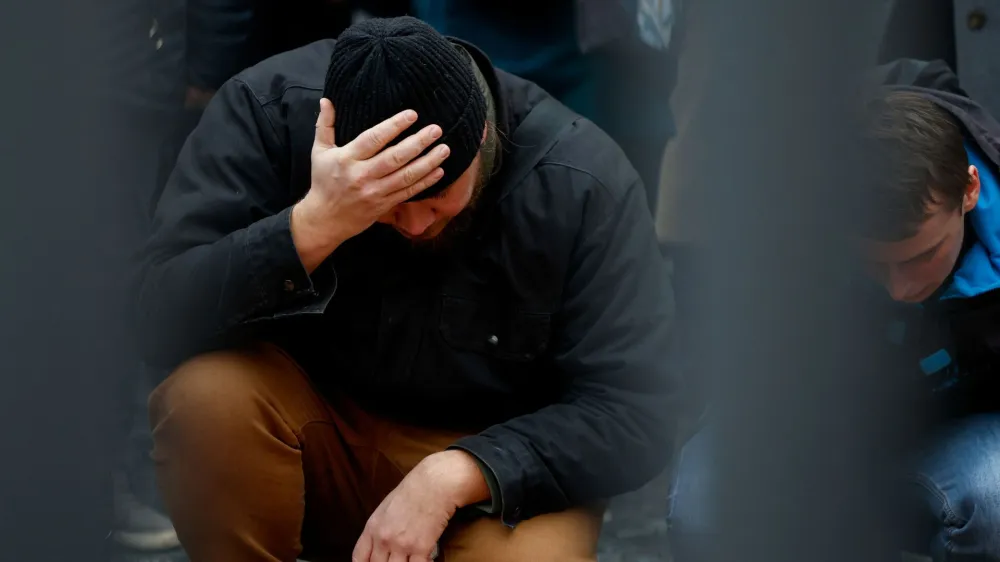 A man reacts at a memorial during a vigil following a shooting at one of Charles University's buildings in Prague, Czech Republic, December 22, 2023. REUTERS/David W Cerny