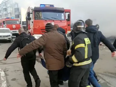 People, including firefighters, carry a person away from the site following what was said to be Ukrainian forces' shelling in the course of Russia-Ukraine conflict, in Belgorod, Russia December 30, 2023, in this still image taken from video. Russian Emergencies Ministry/Handout via REUTERS ATTENTION EDITORS - THIS IMAGE HAS BEEN SUPPLIED BY A THIRD PARTY. NO RESALES. NO ARCHIVES. MANDATORY CREDIT.