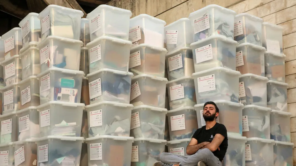 FILE PHOTO: An electoral worker sits next to boxes as Lebanese await the official election results for the rest of the districts in Lebanon's parliamentary election, at the Justice Palace in Jdeideh, Lebanon May 16, 2022. REUTERS/Mohamed Azakir/File Photo