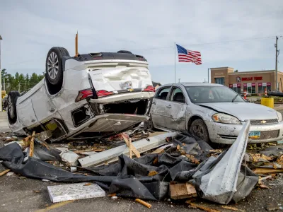 Two heavily-damaged vehicles rest in the Hobby Lobby parking lot amid the damage and aftermath from a tornado the day before along Michigan state Highway 32, Saturday, May 21, 2022, in Gaylord, Mich. (Jake May/MLive.com/The Flint Journal via AP)