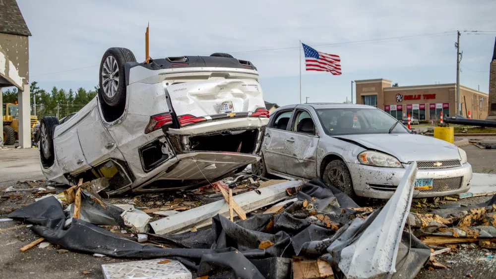 Two heavily-damaged vehicles rest in the Hobby Lobby parking lot amid the damage and aftermath from a tornado the day before along Michigan state Highway 32, Saturday, May 21, 2022, in Gaylord, Mich. (Jake May/MLive.com/The Flint Journal via AP)