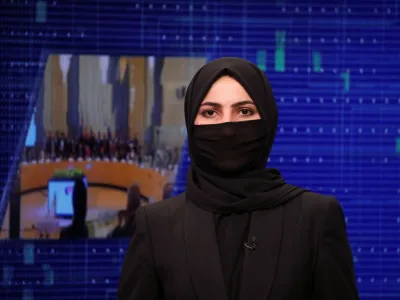 A female presenter for Tolo News, Sonia Niazi, while covering her face, works in a newsroom at Tolo TV station in Kabul, Afghanistan, May 22, 2022. REUTERS/Ali Khara