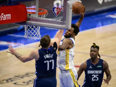 May 22, 2022; Dallas, Texas, USA; Golden State Warriors forward Andrew Wiggins (22) dunks the ball over Dallas Mavericks guard Luka Doncic (77) during the fourth quarter in game three of the 2022 western conference finals at American Airlines Center. Mandatory Credit: Jerome Miron-USA TODAY Sports