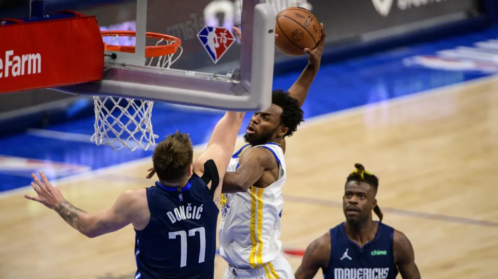 May 22, 2022; Dallas, Texas, USA; Golden State Warriors forward Andrew Wiggins (22) dunks the ball over Dallas Mavericks guard Luka Doncic (77) during the fourth quarter in game three of the 2022 western conference finals at American Airlines Center. Mandatory Credit: Jerome Miron-USA TODAY Sports