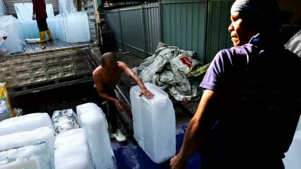 Workers unload blocks of ice from a truck at a market as Thai authorities said that people were dying from heat stroke this year and warned to avoid outdoor activities, in Bangkok, Thailand, May 2, 2024. REUTERS/Athit Perawongmetha