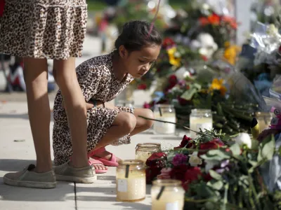 A child looks at a memorial site for the victims killed in this week's shooting at Robb Elementary School in Uvalde, Texas, Friday, May 27, 2022. (AP Photo/Dario Lopez-Mills)