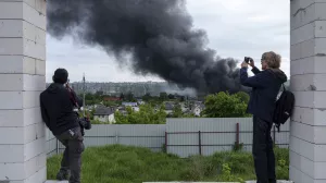 Foreign journalists report from an observation point while smoke rises after a Russian attack in Kharkiv, Ukraine, Friday, May 17, 2024. (AP Photo/Evgeniy Maloletka)