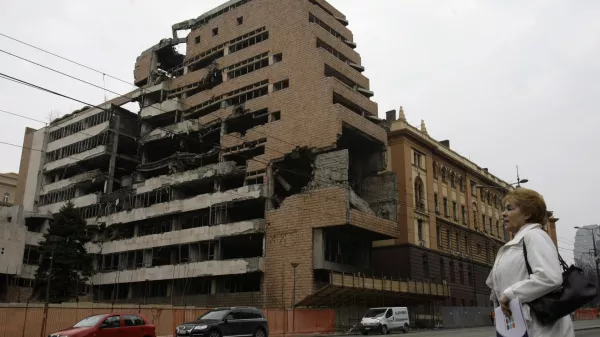 FILE- A woman walks in front of the destroyed former Serbian army headquarters in Belgrade, Serbia, March 24, 2010. Opposition groups in Serbia are planning protests against a real estate development project that will be financed by the firm of Donald Trump's son-in-law, Jared Kushner, at the site of the former Serbian army headquarters destroyed in a U.S.-led NATO bombing campaign in 1999. The Serbian government earlier this week signed a deal with a Kushner-related company for the 99-year lease of land in central Belgrade for the "revitalization" of the bombed-out buildings. (AP Photo/Darko Vojinovic, File)