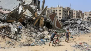 21 May 2024, Palestinian Territories, Khan Yunis: Palestinian children walk past their destructed homes in Hamad Town, after they returned following the withdrawal of the Israeli army. The town like almost all of Gaza is massively destructed. Photo: Abed Rahim Khatib/dpa