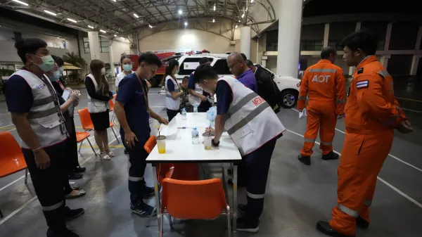 Members of a rescue team discuss after a London-Singapore flight was diverted to Bangkok due to severe turbulence, in Bangkok, Thailand, Tuesday, May 21, 2024. The plane apparently plummeted for a number of minutes before it was diverted to Bangkok, where emergency crews rushed to help injured passengers amid stormy weather, Singapore Airlines said Tuesday. (AP Photo/Sakchai Lalit)