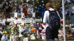 A man kneels at a memorial outside Robb Elementary School to honor the victims killed in a school shooting in Uvalde, Texas Sunday, May 29, 2022. (AP Photo/Dario Lopez-Mills)