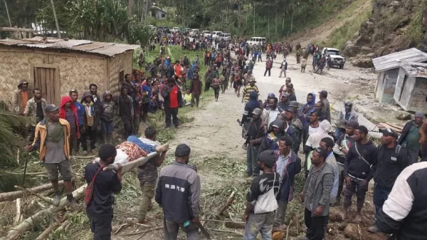 In this photo provided by the International Organization for Migration, an injured person is carried on a stretcher to seek medical assistance after a landslide in Yambali village, Papua New Guinea, Friday, May 24, 2024. More than 100 people are believed to have been killed in the landslide that buried a village and an emergency response is underway, officials in the South Pacific island nation said. The landslide struck Enga province, about 600 kilometers (370 miles) northwest of the capital, Port Moresby, at roughly 3 a.m., Australian Broadcasting Corp. reported. (Benjamin Sipa/International Organization for Migration via AP)