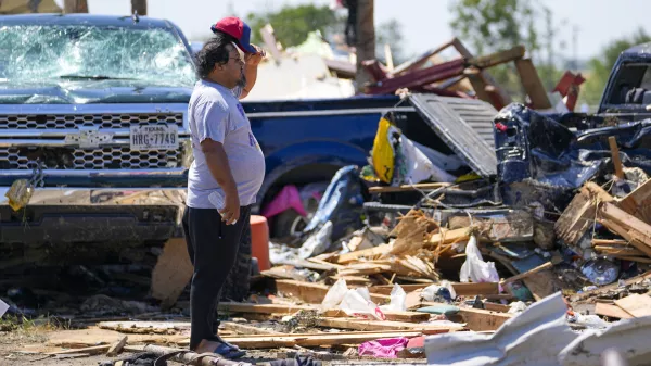 A man looks over debris at an area where people reportedly died during a deadly tornado as it rolled through, Sunday, May 26, 2024, in Valley View, Texas. Powerful storms left a wide trail of destruction Sunday across Texas, Oklahoma and Arkansas after obliterating homes and destroying a truck stop where drivers took shelter during the latest deadly weather to strike the central U.S. (AP Photo/Julio Cortez)