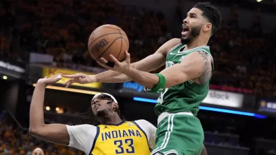 Boston Celtics forward Jayson Tatum (0) drives to the basket over Indiana Pacers center Myles Turner (33) during the first half of Game 4 of the NBA Eastern Conference basketball finals, Monday, May 27, 2024, in Indianapolis. (AP Photo/Michael Conroy)