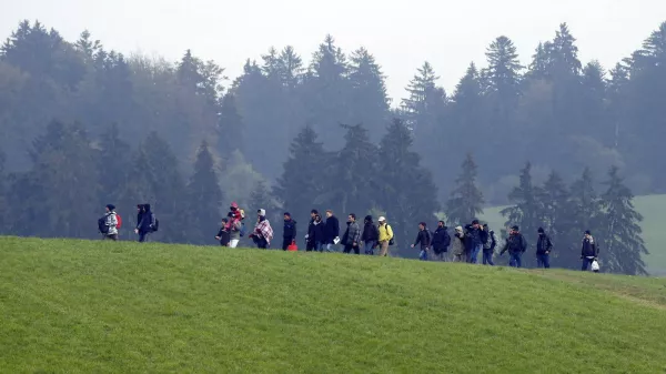 ﻿File photo of migrants crossing a field as they walk from the Austrian village of Kollerschlag towards the Austrian-German border in Wegscheid near Passau, Austria, October 20, 2015. In September, the leaders of Austria and Germany took one of the most pivotal decisions of Europe's refugee crisis, throwing open their borders to tens of thousands of migrants piling up in Hungary. Nearly half a year on, however, the display of unity over the Sept. 5-6 weekend is a distant memory. In a sign of how deep Europe's divisions over refugees have become, Berlin and Vienna snipe at each other almost daily. REUTERS/Michael Dalder/Files