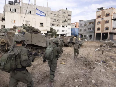 FILE - Israeli soldiers walk in Gaza City's Shijaiyah neighborhood on Dec. 8, 2023, as part of an operation to round up hundreds of Palestinians across the northern Gaza Strip and truck some to an undisclosed location. (AP Photo/Moti Milrod, Haaretz, File)