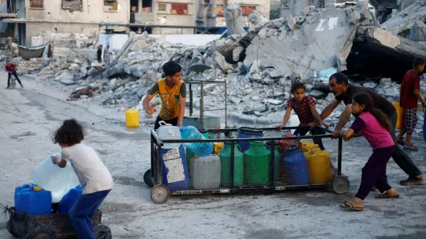 FILE PHOTO: A Palestinian man and children push a cart with water containers, amid the ongoing conflict between Israel and Hamas, in southern Gaza City, in the Gaza Strip, June 3, 2024. REUTERS/Mohammed Salem/File Photo