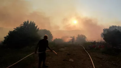 A man holds a hose, as another person uses a hose to extinguish flames, amid ongoing cross-border hostilities between Hezbollah and Israeli forces, in Dishon, near Kiryat Shmona, northern Israel, June 4, 2024. REUTERS/Ammar Awad   TPX IMAGES OF THE DAY