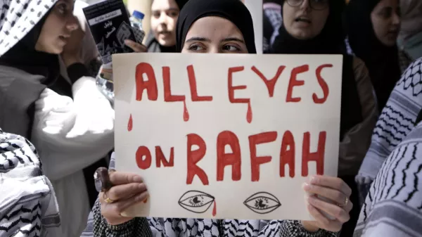 FILE - A student holds a placard as she chants slogans during a protest inside the American University of Beirut to show support for Palestinians in the Gaza Strip, in Beirut, Lebanon, Tuesday, May 7, 2024. A single image, not even an authentic photograph, is the focus of a singular campaign on Instagram that has caught the attention of the algorithm and captured the imaginations of users across national borders — a show of support for the Palestinian movement as the war between Israel and Hamas enters its eighth month. (AP Photo/Bilal Hussein, File)