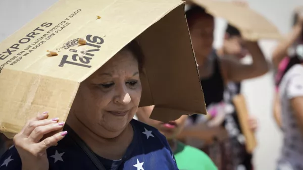 FILE - Margaret Cantu waits in the heat for food and water from volunteers Saturday, May 18, 2024, at Sam Houston Math, Science and Technology Center in Houston. (Jon Shapley/Houston Chronicle via AP)/Houston Chronicle via AP, File)