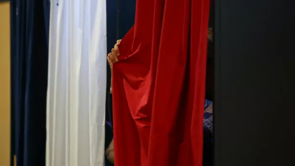 A person pulls the curtain inside a voting booth during the European Parliament election, in Le Touquet-Paris-Plage, France, June 9, 2024. REUTERS/Hannah McKay