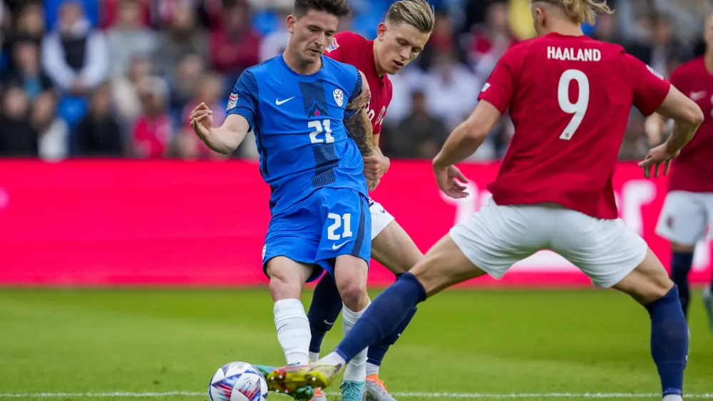 Slovenia's Tomi Horvat, centre, vies for the ball with Norway's Marcus Holmgren Pedersen, background and Erling Braut Haaland, during the Nations League soccer match between Norway and Slovenia at Ullevaal Stadium, in Oslo, Norway, Thursday, June 9, 2022. (Javad Parsa/NTB Scanpix via AP)